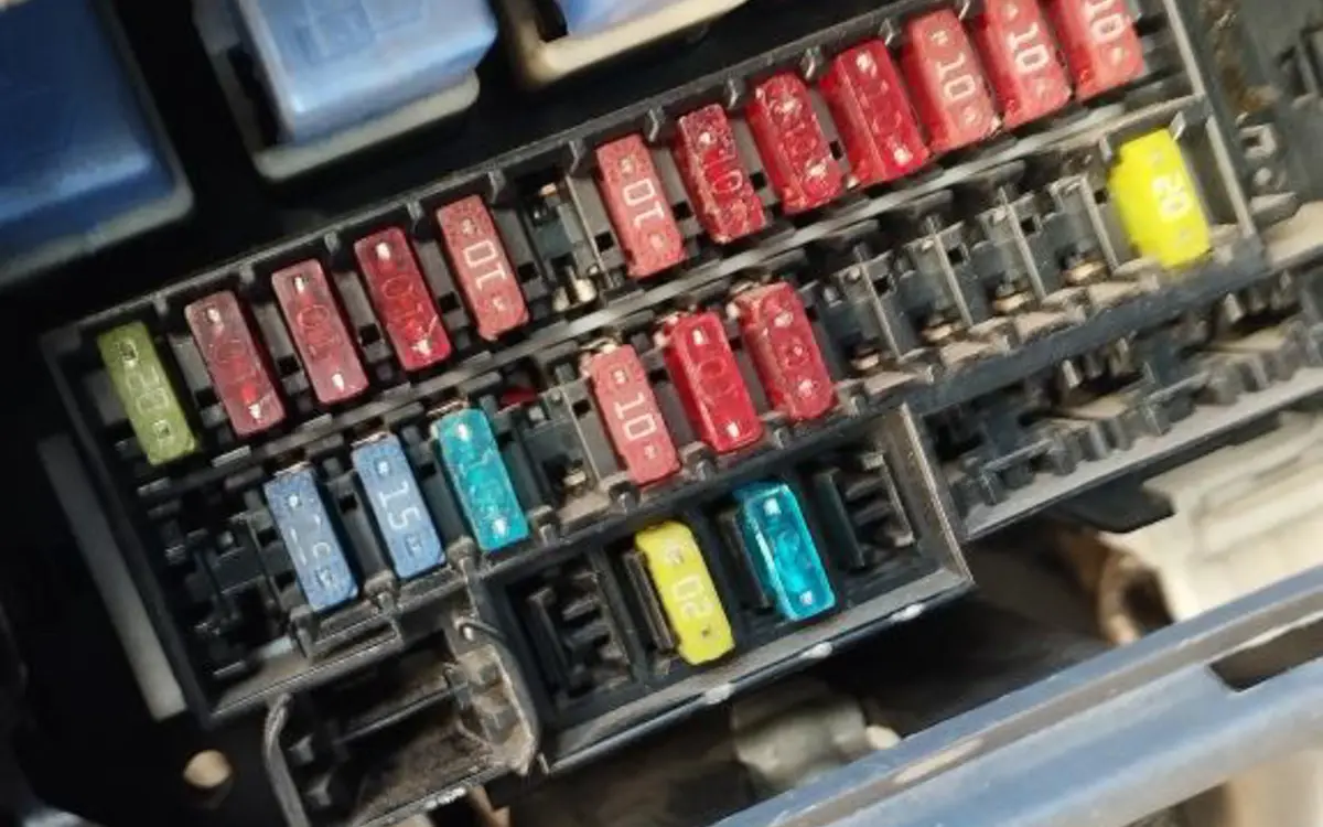 Caja de fusibles y relés durante una revisión eléctrica automotriz